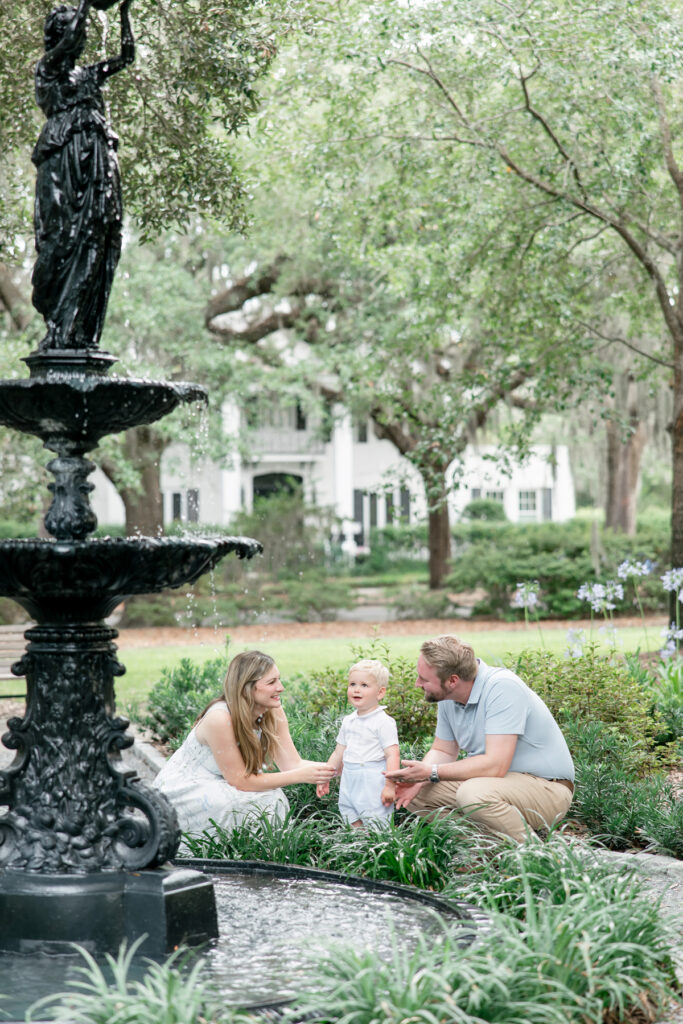 Little boy looks up at the Garden Keeper fountain in Kavanaugh Park in historic Ardsley Park Savannah, GA