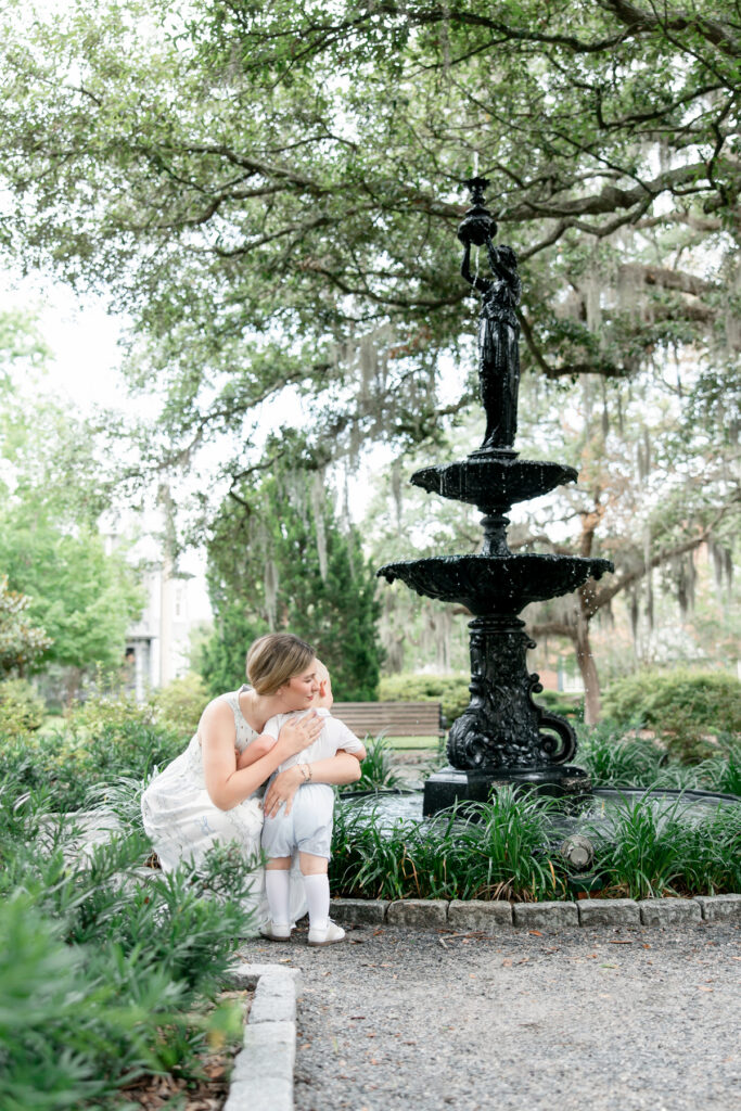 Mom hugging her little boy in front of Savannah fountain