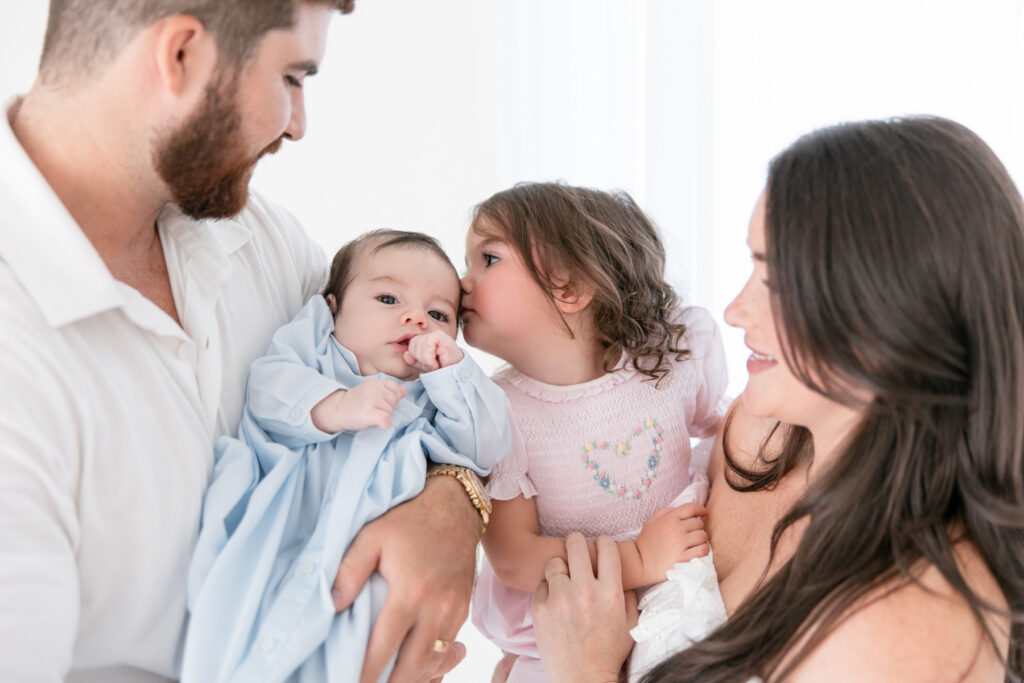 Big sister kissing her baby brother during a Savannah photography session