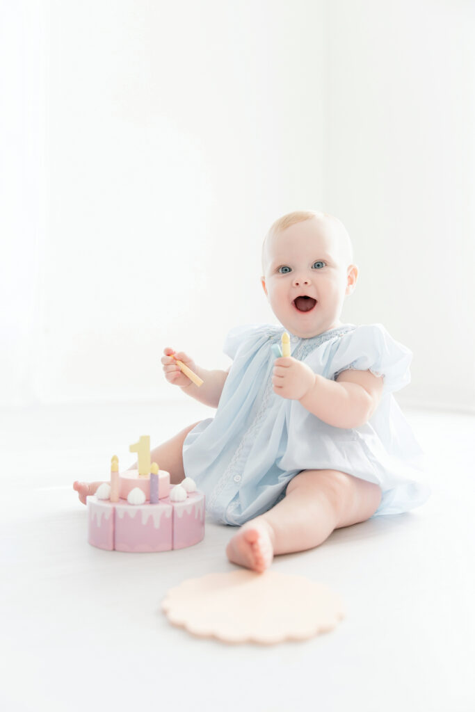 Simple first birthday photos of a baby girl on a white studio background