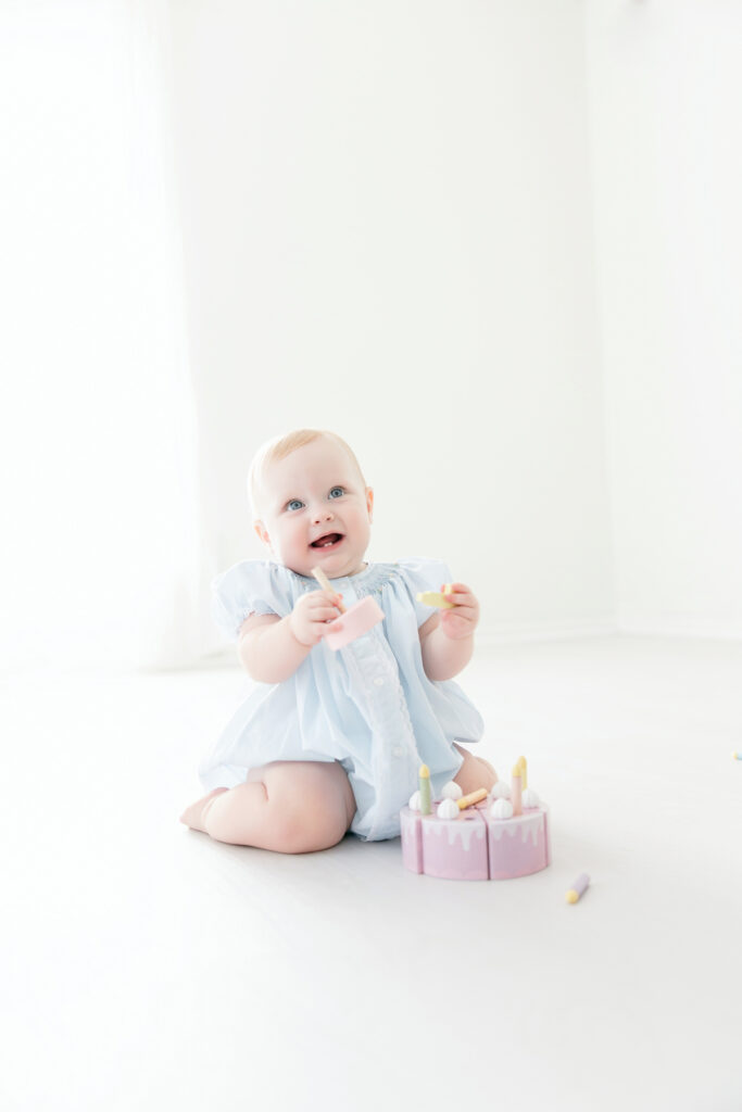 Baby girl sitting and smiling during her Savannah first birthday photos