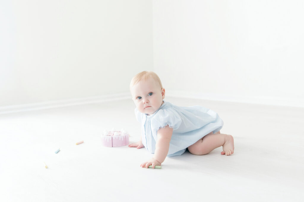 Simple first birthday photos of a baby girl on a white studio background