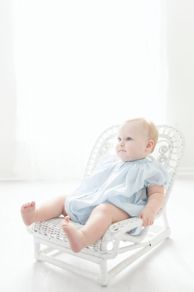 First birthday session with baby in blue bubble and white wicker chair